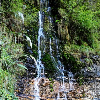 Waterfall covering the entire cliff on Kuari Pass Trek